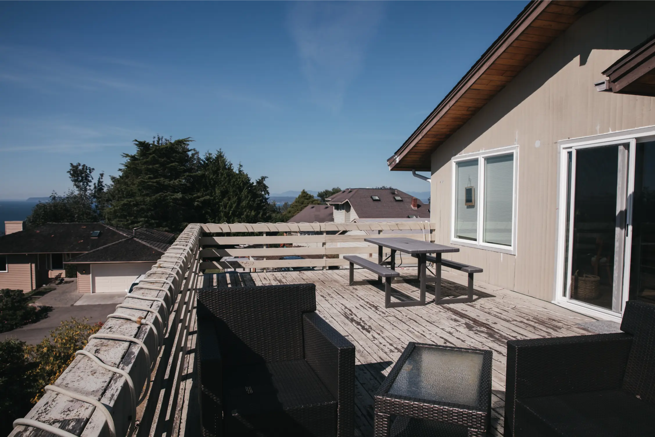 Outdated deck space with faded boards and limited seating area.