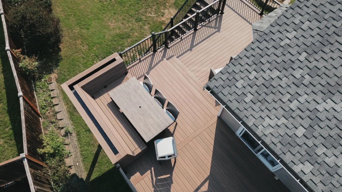 Aerial view of composite deck with U-shaped built-in bench seating around a dining table