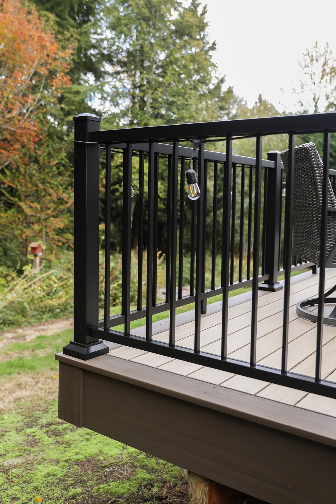 Close-up of black aluminum picket deck railing with square post and post cap