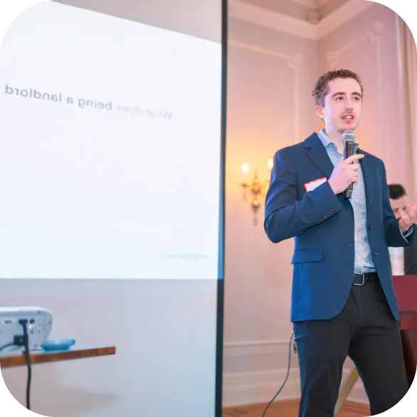 Man in a suit standing holding mic