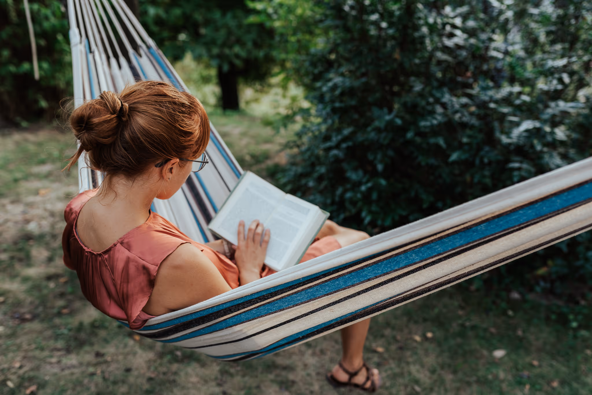O fată citește într-un hamac.