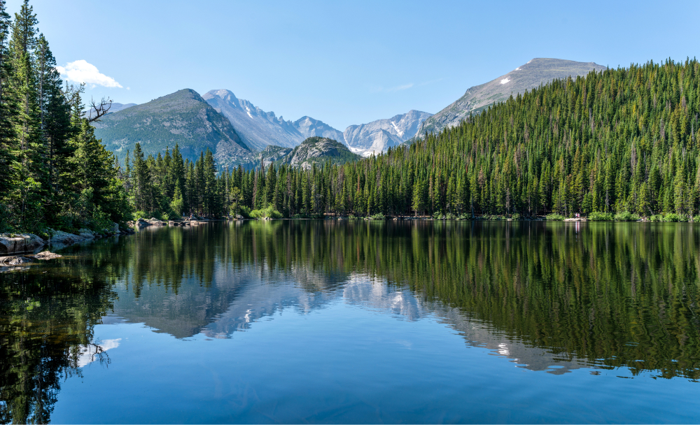 Longs Peak near Fort Collins in the summer near a clear mountain lake.