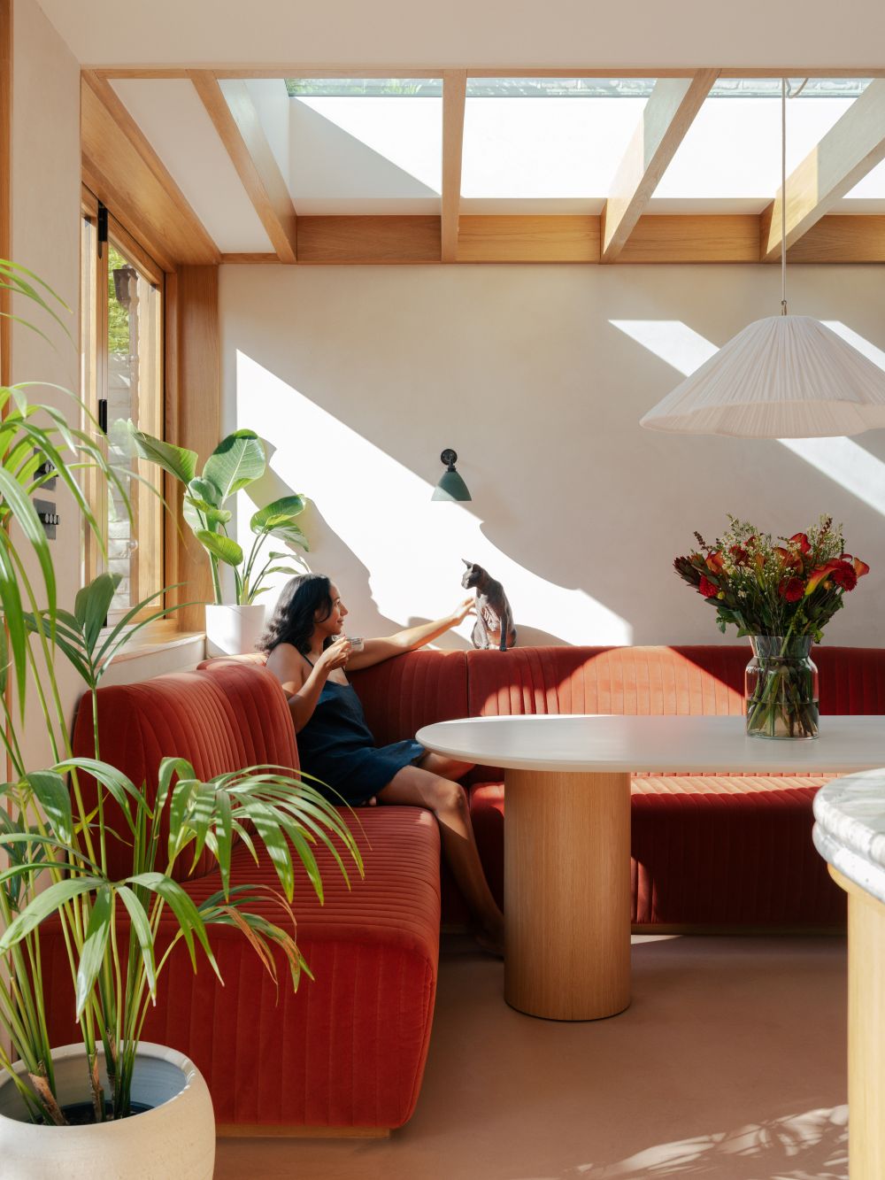 A warm toned dining banquette with roof light by Benjamin Wilkes in London