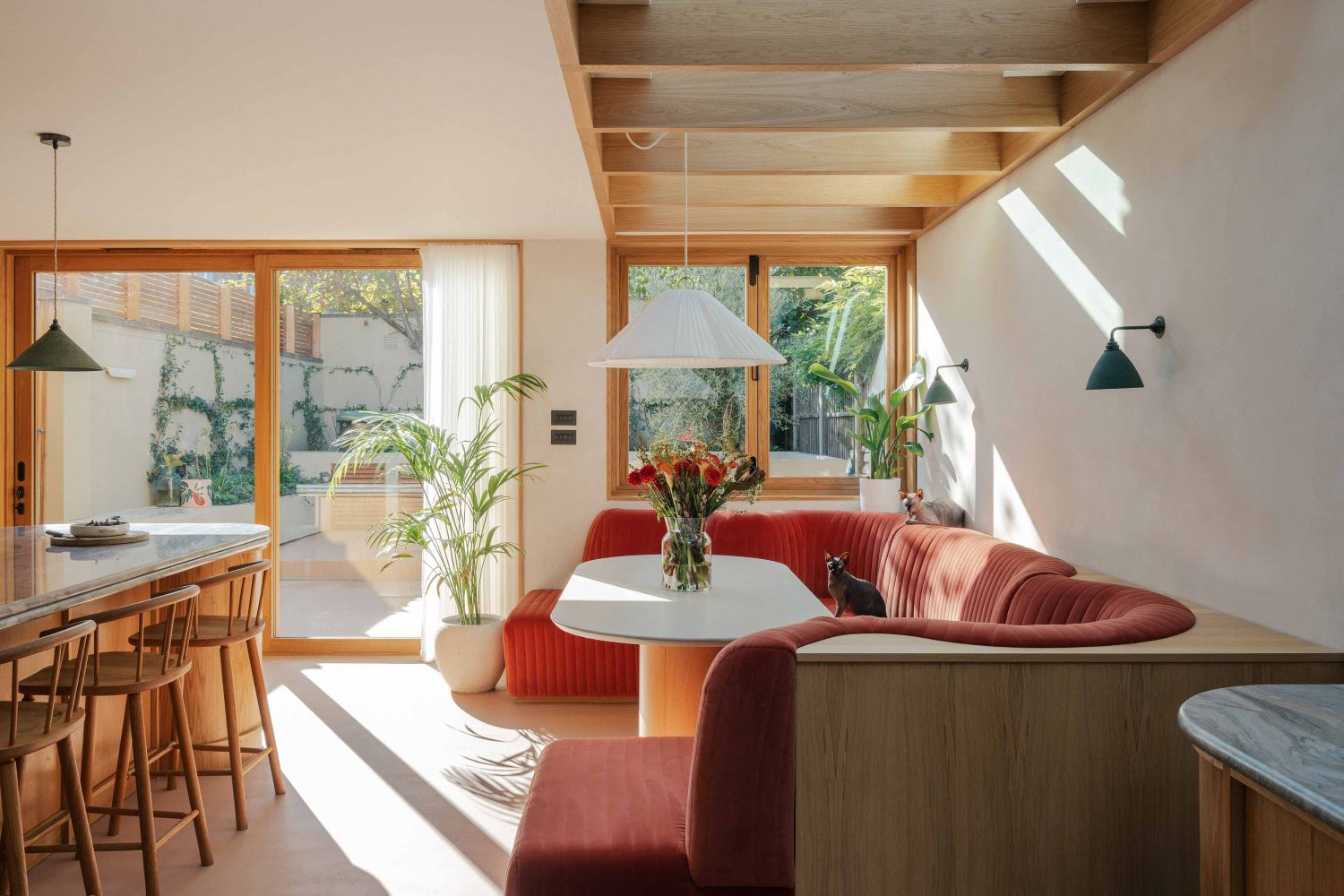 Velvet dining banquette seating area with skylight above in London