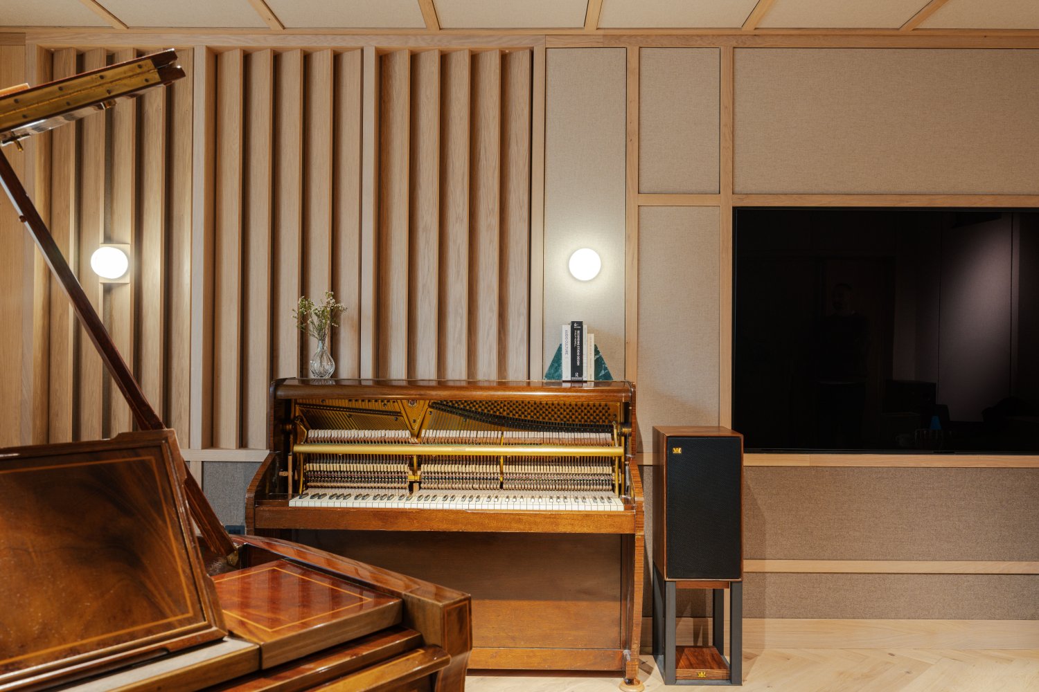 Two pianos in the calming wood panelled Composers Studio music room in a London based home
