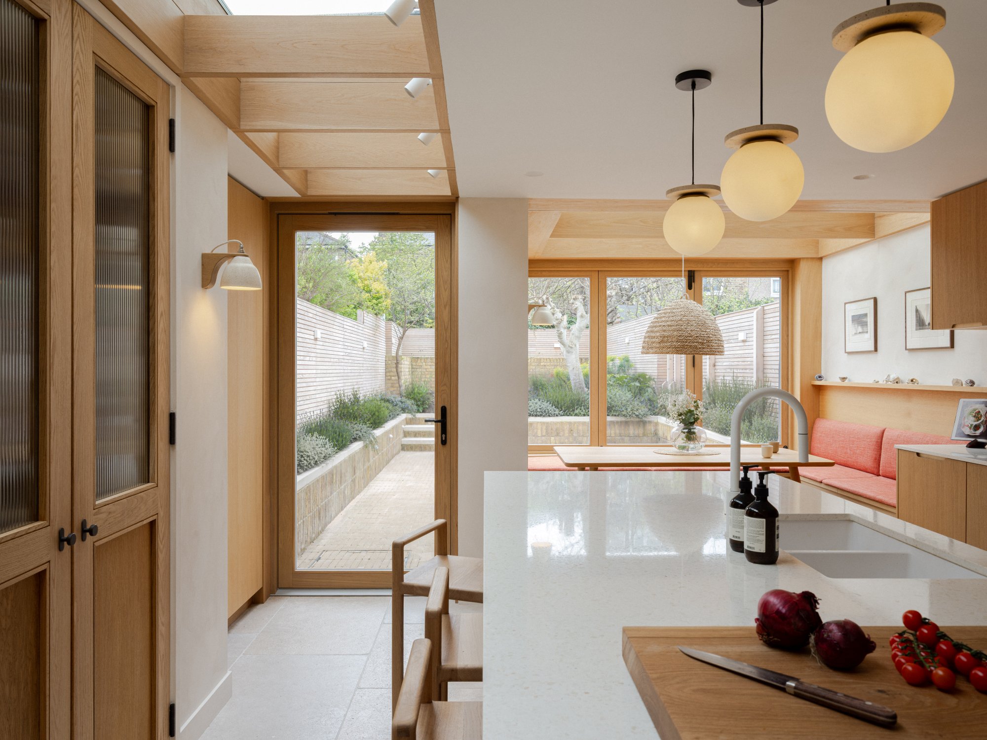 Light-filled kitchen diner with a seamless view into the garden at Strata House, an architectural extension by Benjamin Wilkes in London.