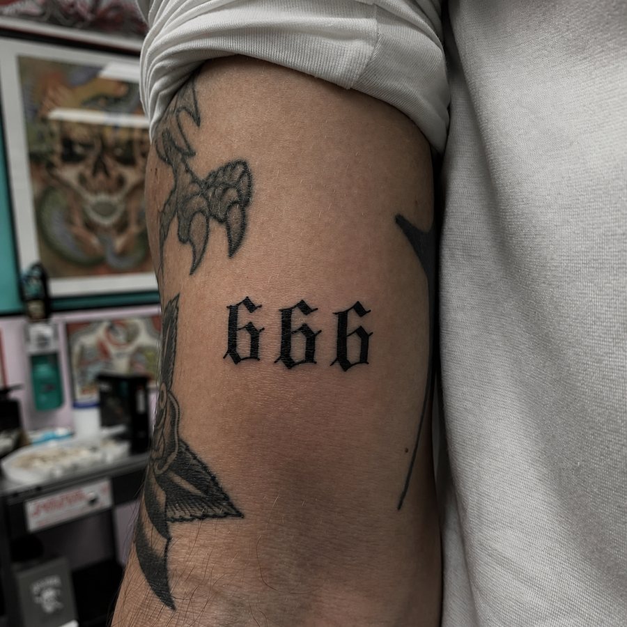 Blackletter 666 tattoo on an arm