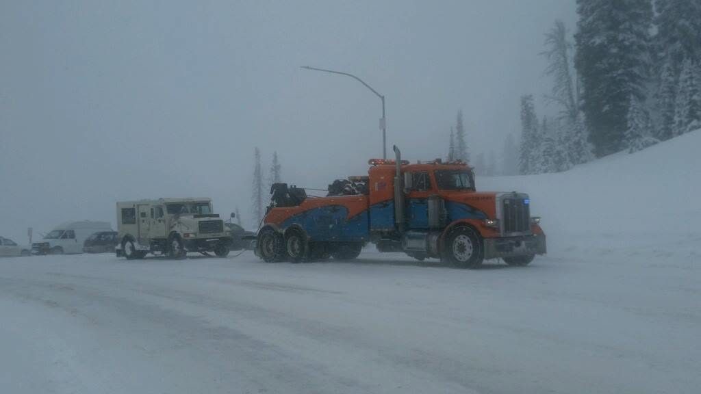 Ron's Towing heavy wrecker working a blizzard recovery on Teton Pass
