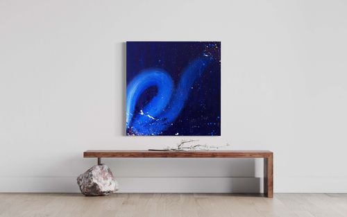 "The Midnight Zone" is a captivating commissioned abstract painting with a bold brushstroke line and heavy use of blue hues and texture. Delicate white, blue, gold, and pink paint splatters are artfully thrown throughout the canvas, adding a touch of whimsy.