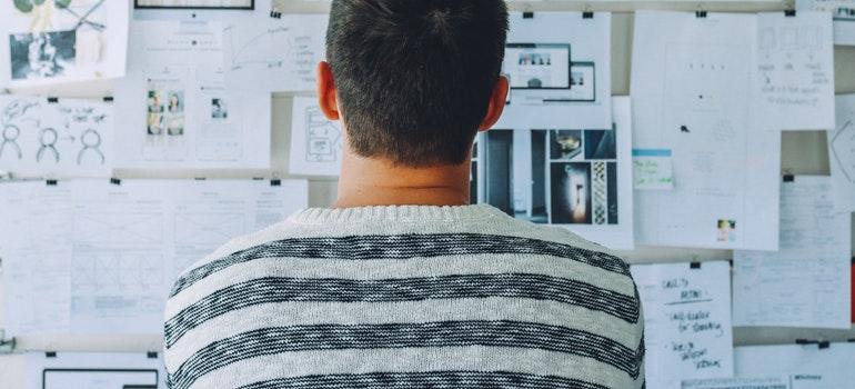 A guy looking at a board after reading homebuyers guide to CA real estate market