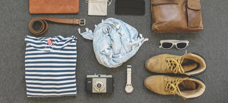 Wardrobe, shoes, belt, glasses, watch and camera on the floor