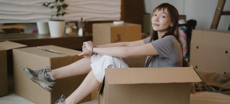 A woman sitting in a moving box