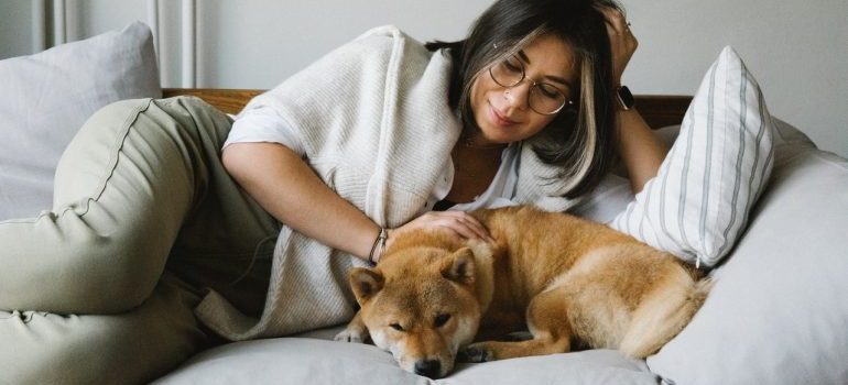 Woman petting her dog on the bed