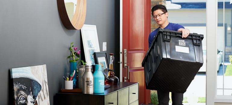 Man in blue shirt packing items in plastic crates
