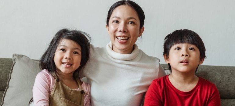 woman with two kids watching tv