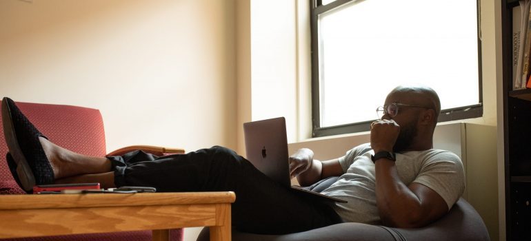 Picture of a man working on laptop. Finding job after the move is easy if you can work remotely