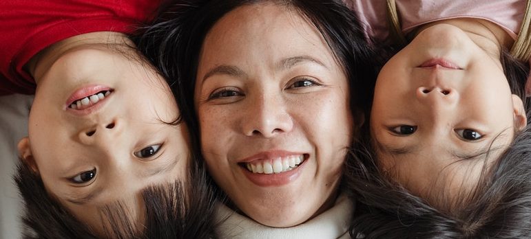 A mother and two children smiling
