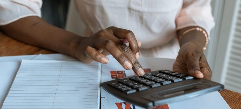 person in white dress shirt using a calculator