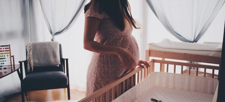 A woman next to babys crib