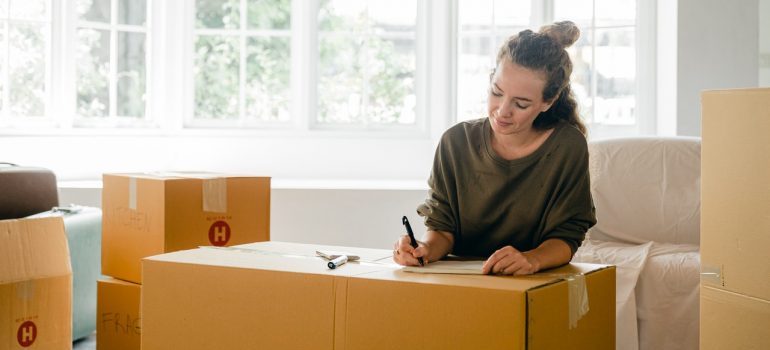 A woman labeling a box