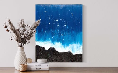 'Chaos in the Ocean Breeze' is an abstract painting with a bold blue palette and textured black background. Swirling tints and shades of blue depict dynamic ocean waves, while vibrant splatters of pink, green, blue, and white add bursts of energy. Heavy layers of paint create depth and dimension. A captivating statement piece that sparks imagination and conversation.