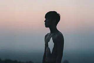 A young man looking out into the distance with a hole in his chest
