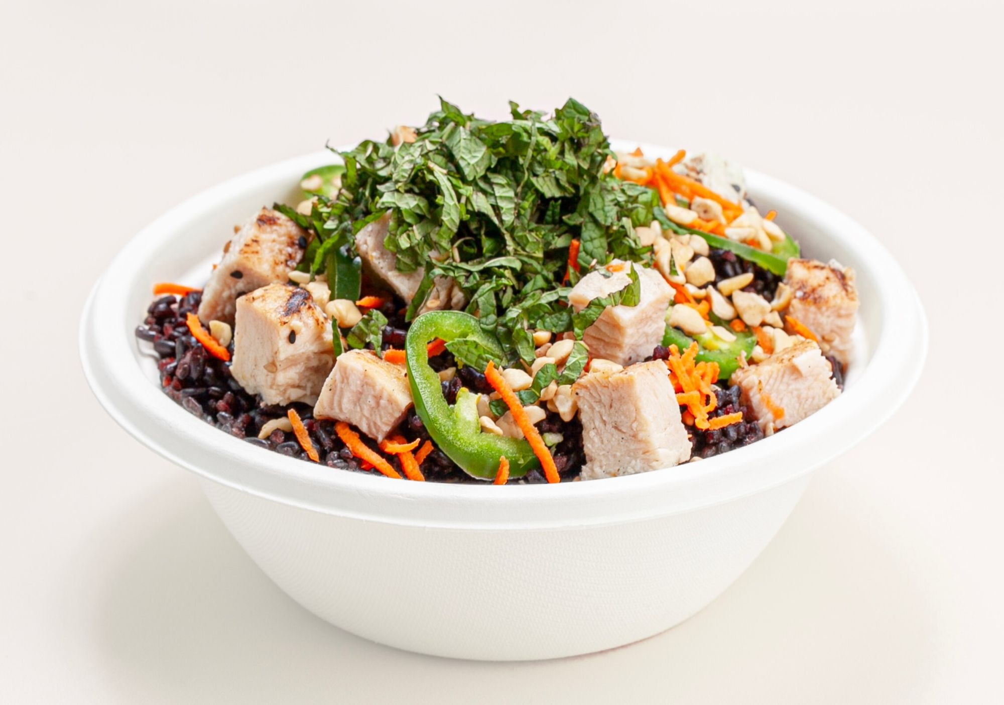 Sweetfin poke bowl with grilled tofu over black rice, jalapeño, shredded carrots, mint, and crushed peanuts.