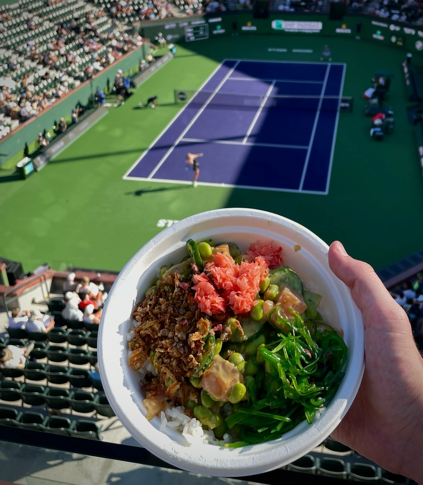 Poke bowl with seaweed salad, edamame, cucumber, and fresh toppings at a tennis match