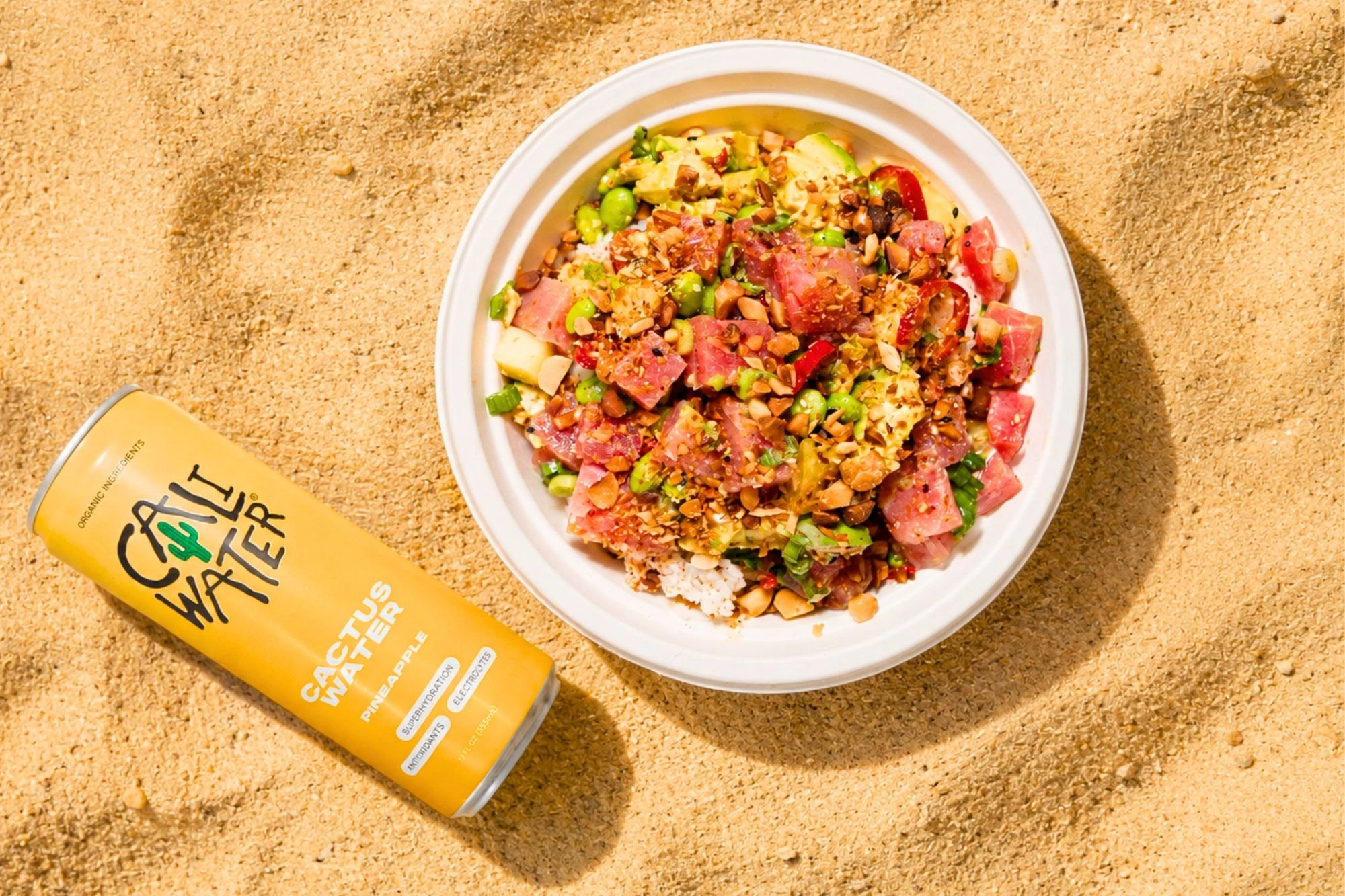 Sweetfin Cali Bowl with tuna, pineapple and avocado beside a Pineapple Caliwater can