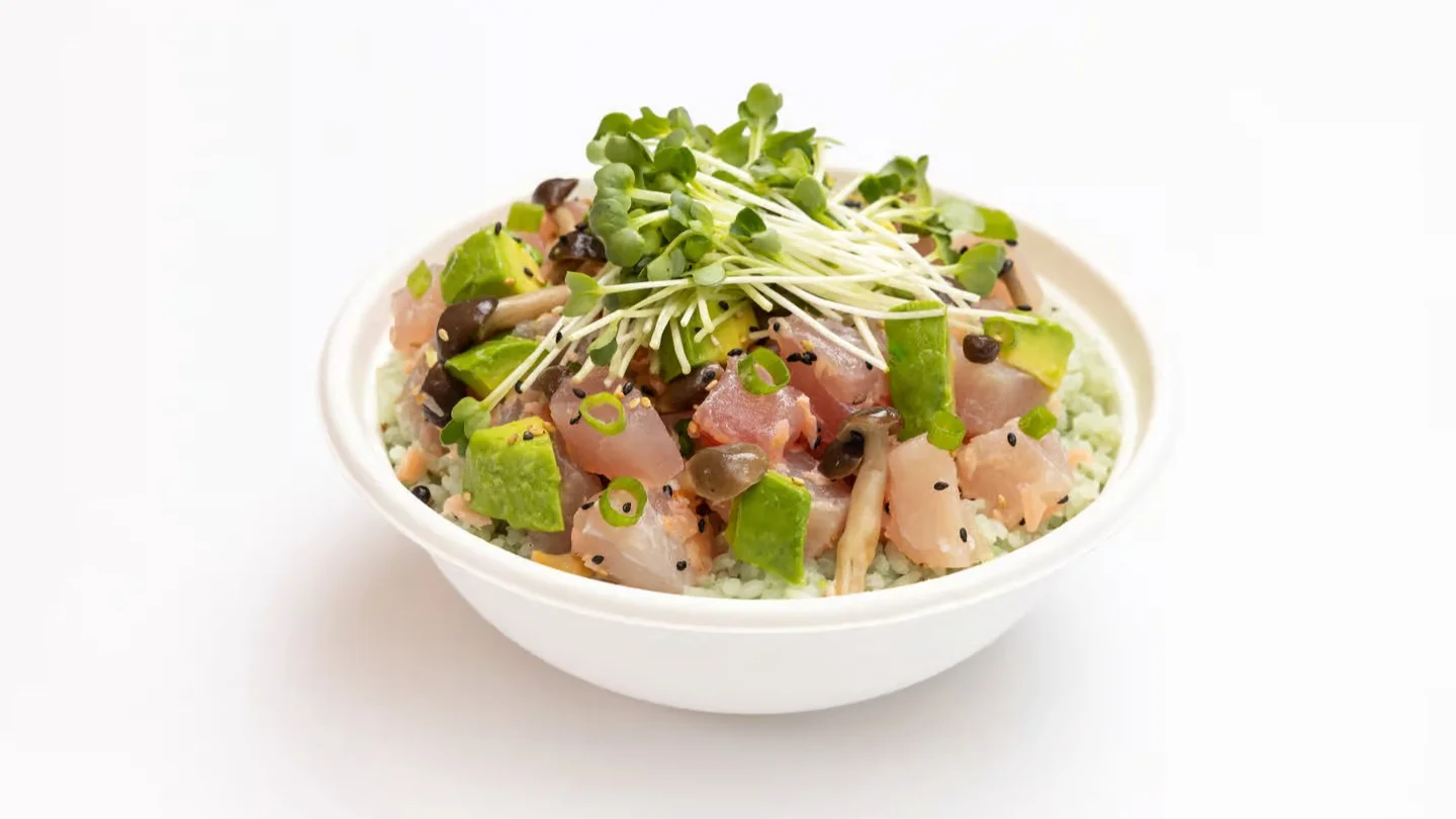 Sweetfin poke bowl with fresh fish, avocado, mushrooms, sprouts, sesame seeds, and green onions over rice.