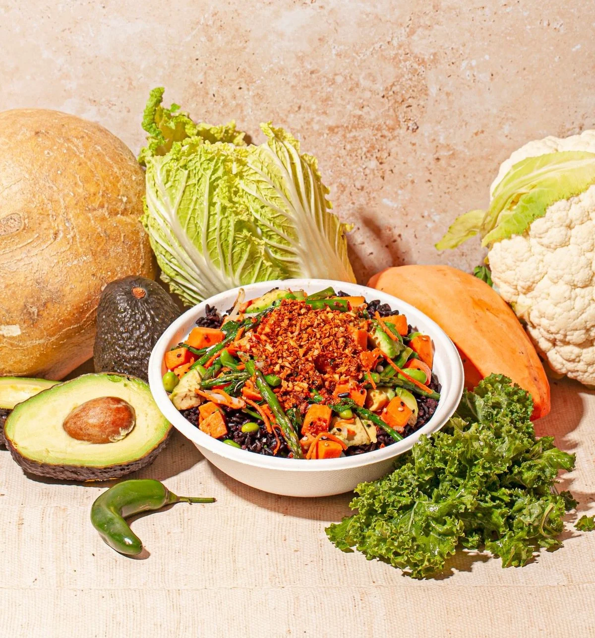 Sweetfin plant-based bowl with sweet potato, avocado, edamame, greens, and crunchy toppings.