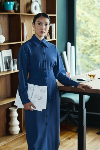 Woman standing next to desk