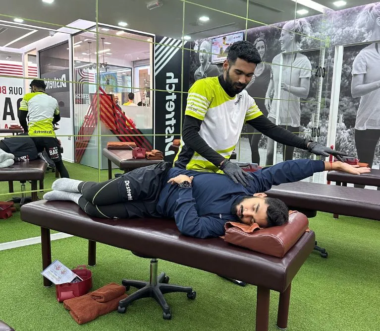 Dr.stretch trainer guiding an assisted leg stretch in a Dubai studio