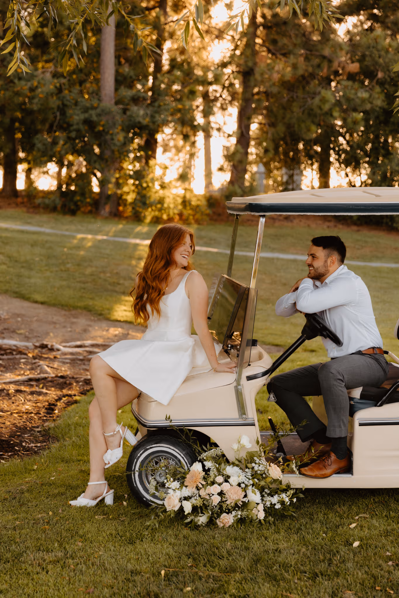 Elegant photo of young engaged couple with vintage golf cart. The couple is posing while dressed in classy engagement style outfits.