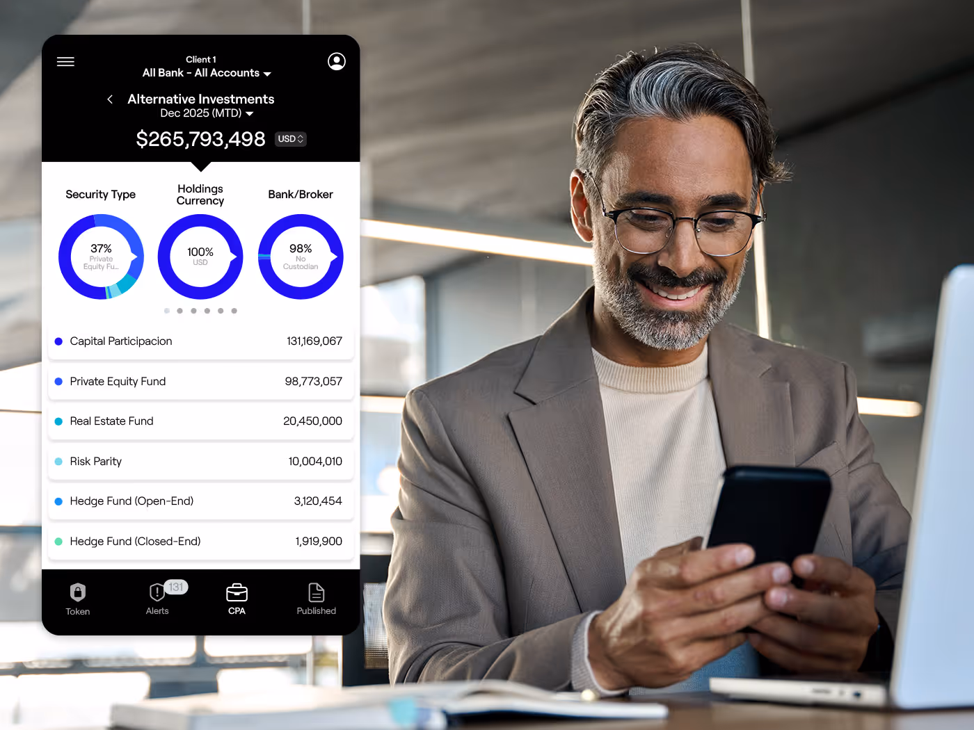 Smiling man in glasses and blazer looking at his smartphone in an office with investment portfolio data displayed on the left.