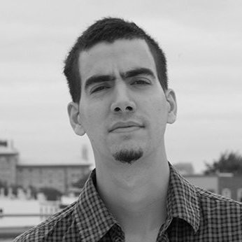 Gonzalo Aragon picture - it's black and white, he's staring at the camera and wearing a plaid shirt.
