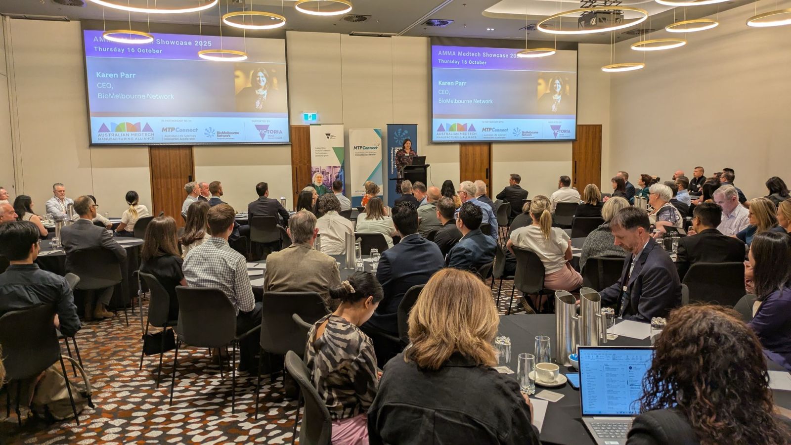 Audience seated in a conference room listening to a speaker presenting on stage at the AMMA Medtech Showcase 2025.