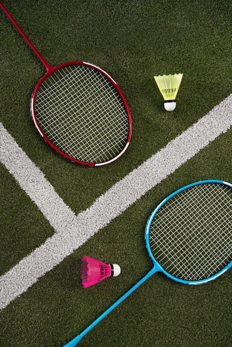 Badminton rackets and shuttlecocks on an indoor court