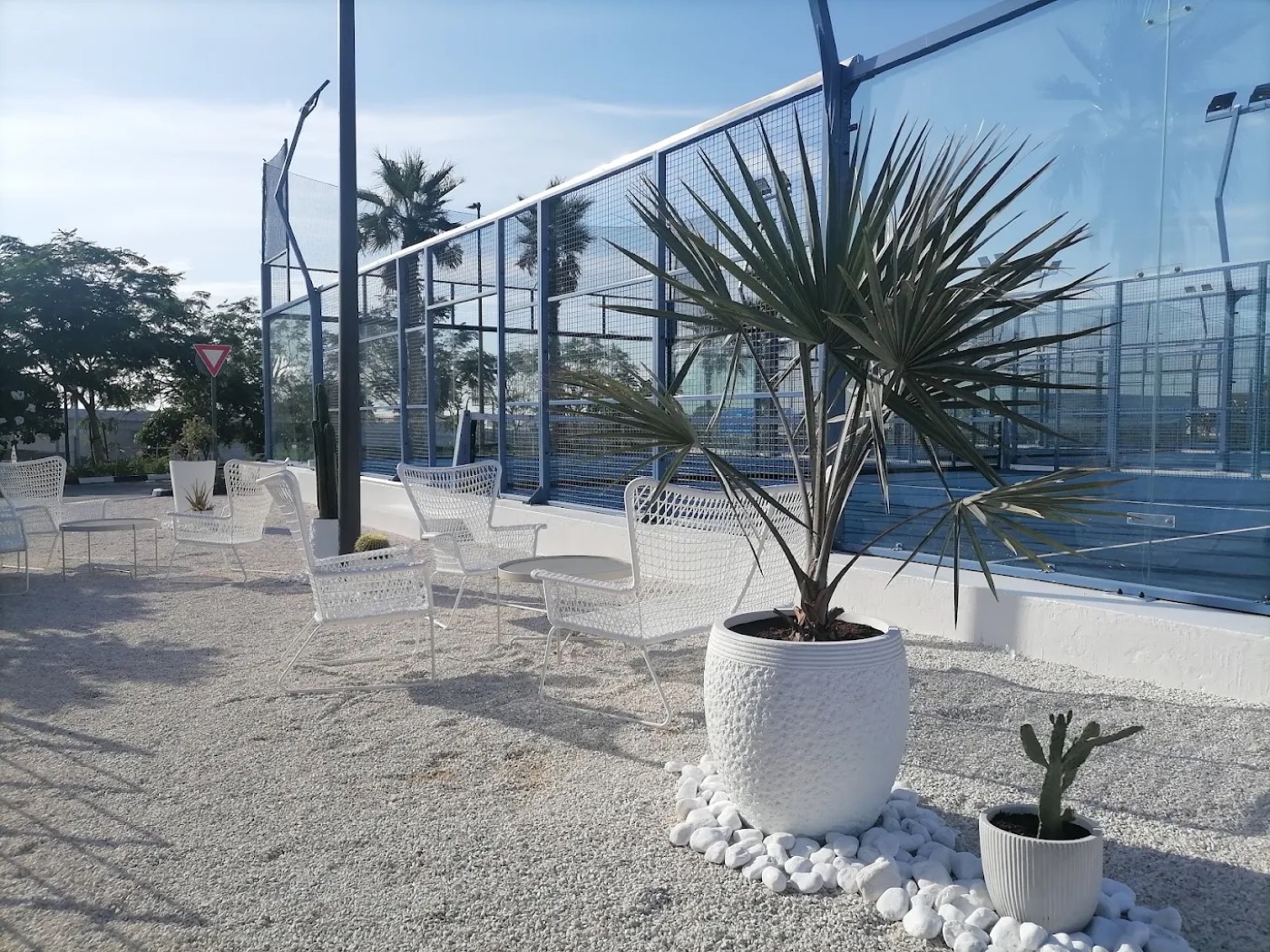 Outdoor lounge seating area beside the padel courts at Top Padel Al Zahia, Sharjah