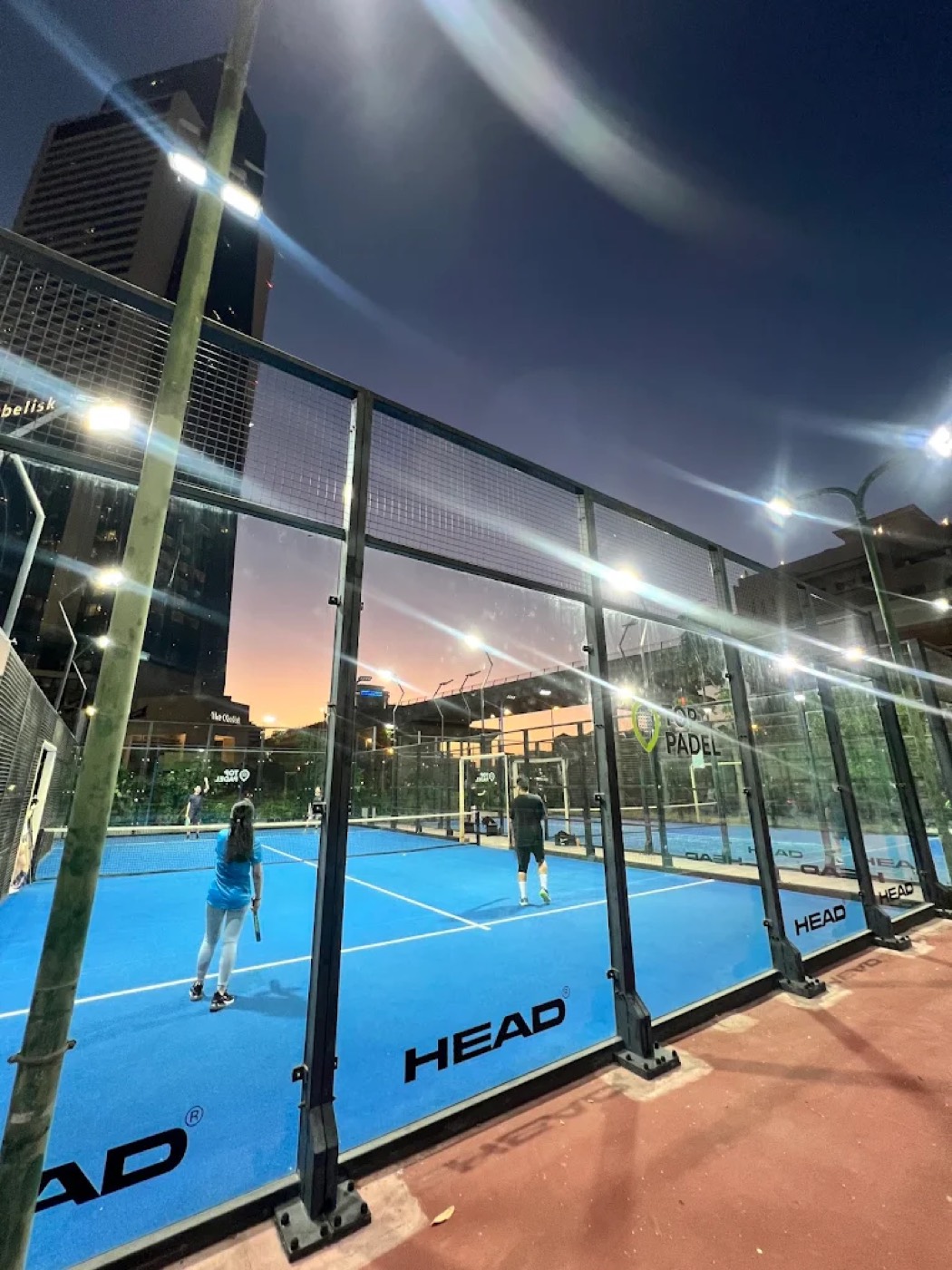 Players on an outdoor padel court at Top Padel Wafi Mall, Dubai, at night