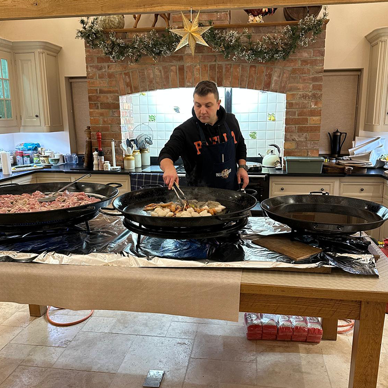Men in a private kitchen preparing paellas