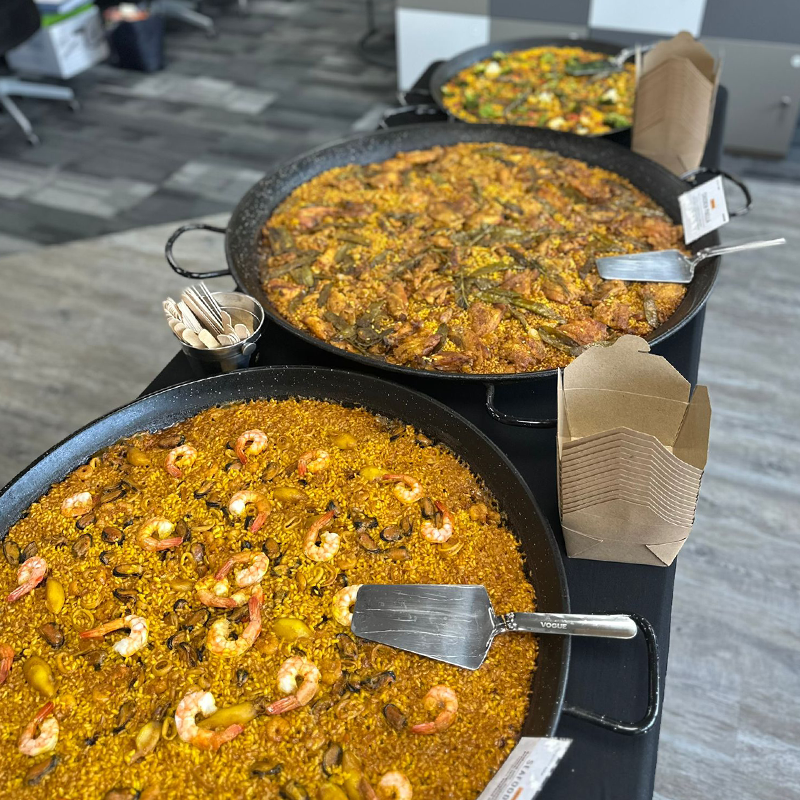 Three paellas in a row, chicken, seafood and veggie paellas
