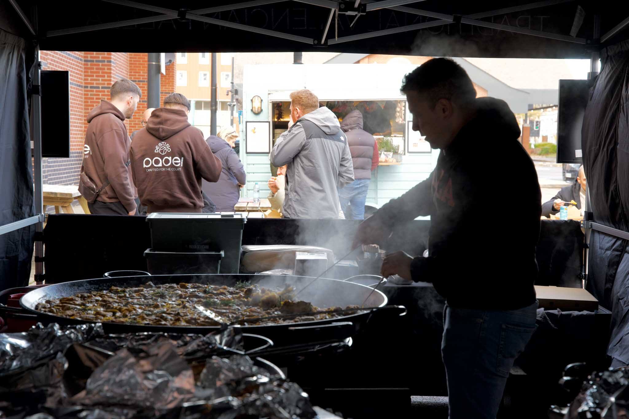 Business owner cooking paella outdoor under a gazebo