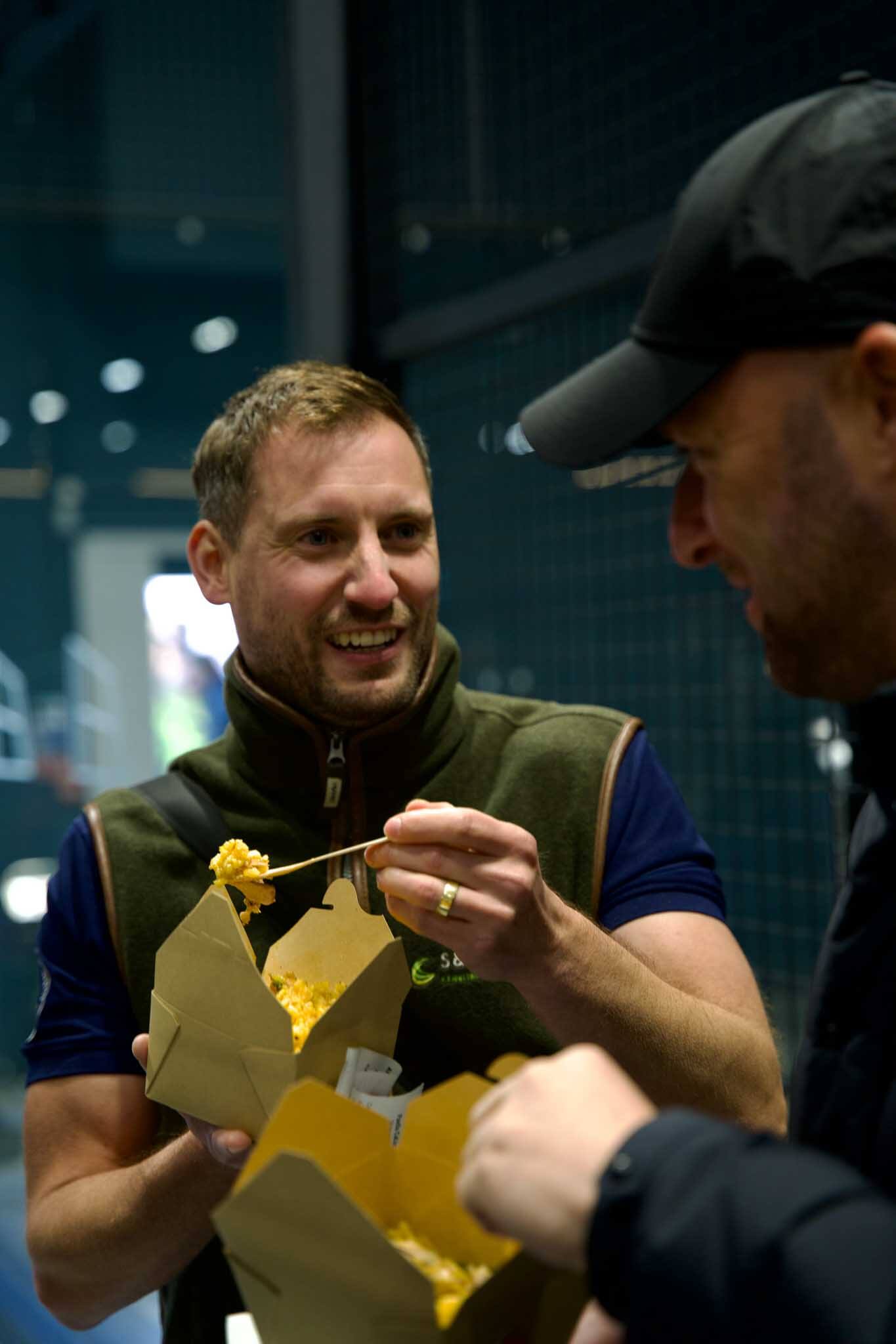 Two man enjoying paella while talking