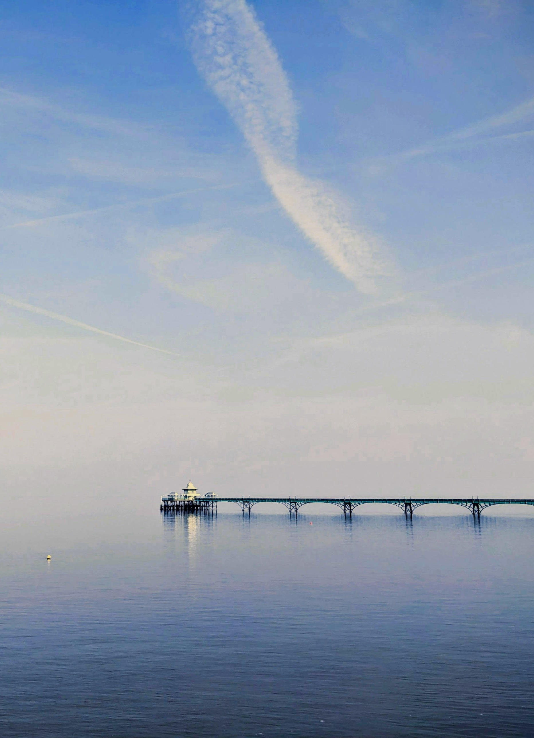 Pier extending into calm water at dusk, photo by John-Mark Strange