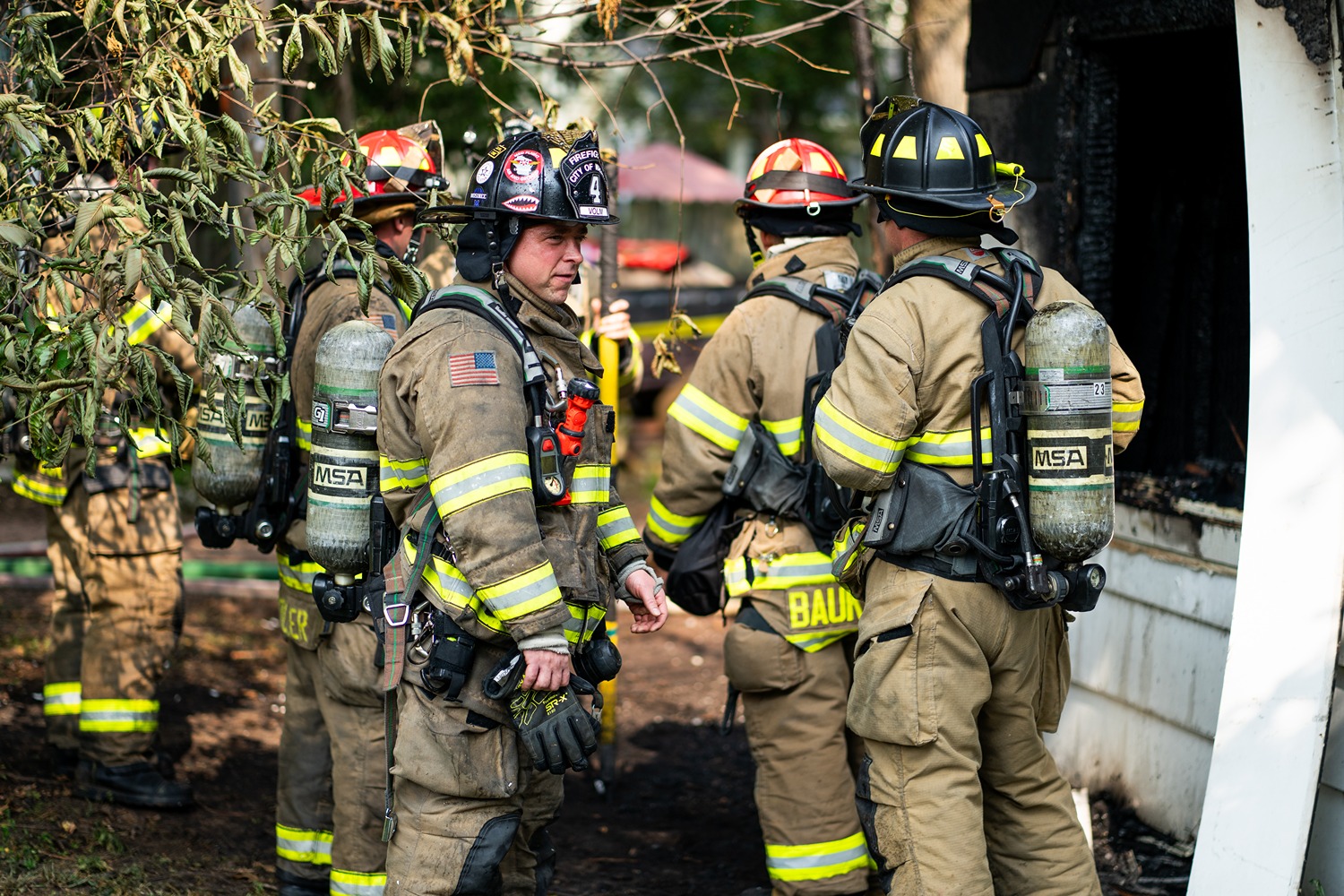 Wausau firefighters in full gear working together at a fire scene