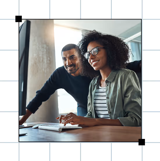 Two coworkers team up at a computer