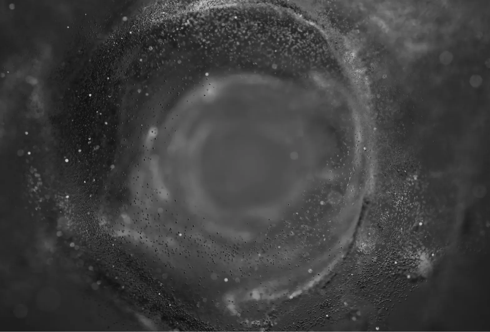 Close-up view of a swirling, nebula-like formation with particles suspended in a dark, misty environment.