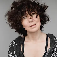 Женщина с тёмными с вьющимися волосами