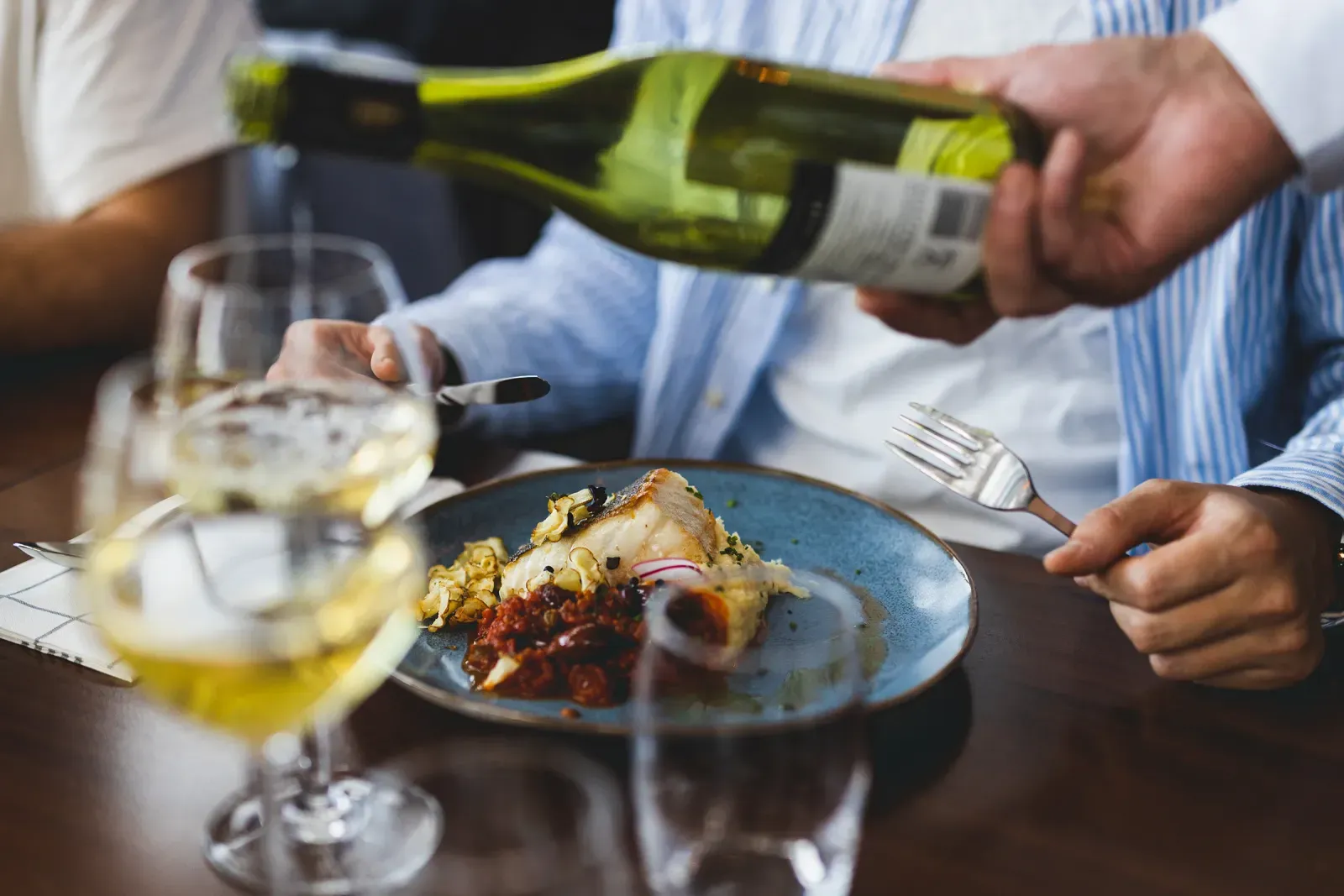 A fish main and a glass of white